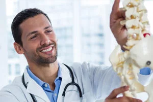 Doctor smiling with spine model