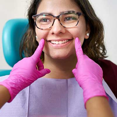 Young dental patient with pink gloves